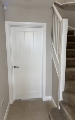 Fresh white painted door with light grey walls